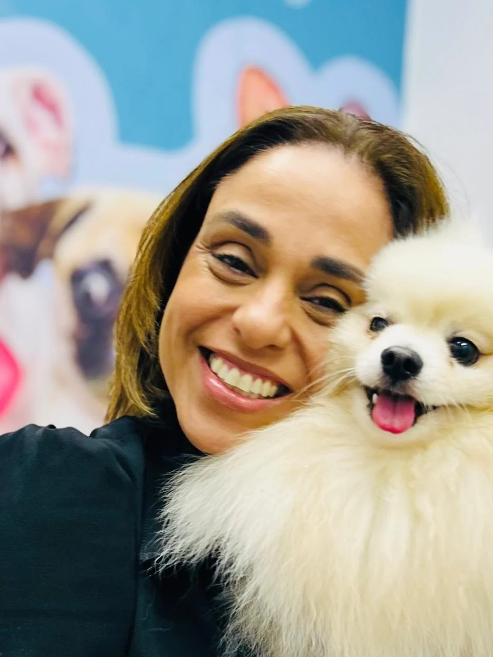 Dra. Caroline Keffer sorrindo de rosto colado a um lulu da pomerânia branco
